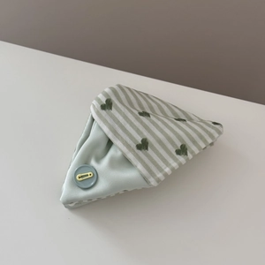 Detail of blue and green striped scrunchie fabric with heart pattern and creative button decoration