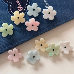 Detailed shot of pastel flower hair claws in macaron colors on denim background