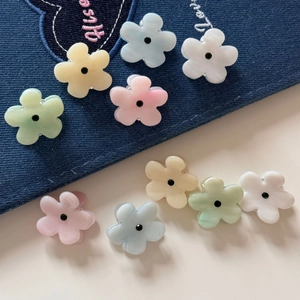 Detailed macro view of colorful mini resin flower hair clips on denim background