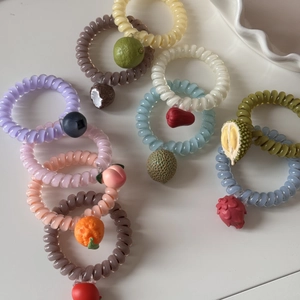 Détails macro des élastiques à cheveux spirales avec pendentifs de fruits en résine