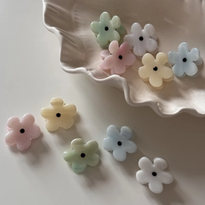 Floral mini hair clips in macaroon colors on a ceramic tray for elegant hairstyles