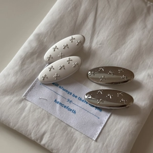 Detail of four-piece bow hair clip set with cream resin and silver metallic finish