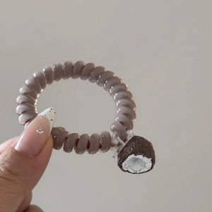 Gros plan sur un élastique spirale violet avec un accessoire de noix de coco