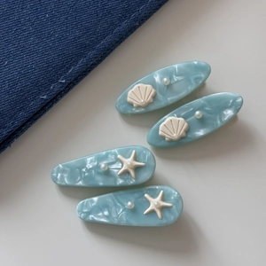 Blue ocean-themed acetate hair clips set with starfish, seashell motifs and pearls