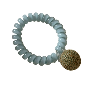 Élastique cheveux spirale bleu clair avec breloque melon vert sur fond blanc