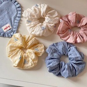 Détails de chouchous en tissu coloré avec d'élégantes broderies de nœuds bleus