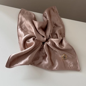 Detail of satin rose jacquard hair scrunchie with golden flower metal accessory