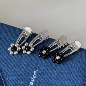 Set of 4 silver metal flower hair clips with bead accents on blue denim fabric