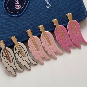 Detail of wing hair clips set with gold metal base and sparkling crystal accents