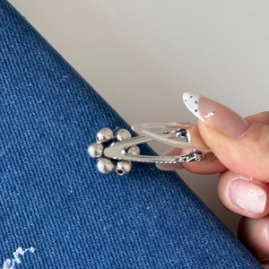 Detail view showing the metal spring mechanism and silver bead flower hair clip