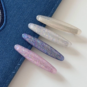 Set of 4 oval glitter hair clips in pearl white, champagne, purple, and soft pink shades