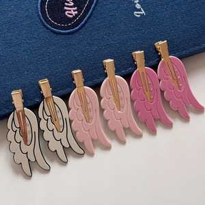 Detailed macro of angel wing hair clips with rhinestones in white pink and rose red
