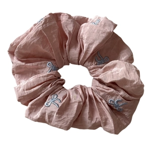 Chouchou rose avec broderie de nœuds bleus et texture en tissu plissé pour la coiffure