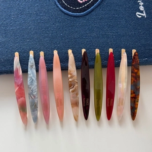 Set of 10 willow leaf resin hair clips with marble patterns on denim background