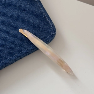 Detail shot of pearl hair clip featuring gold hardware and France Handmade inscription
