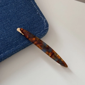 Detailed close-up of handmade tortoiseshell hair clip showing FRANCE engraving