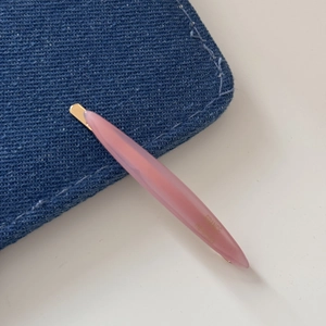 Detail of pink resin hair clip with gold France Handmade engraved text and metal clasp