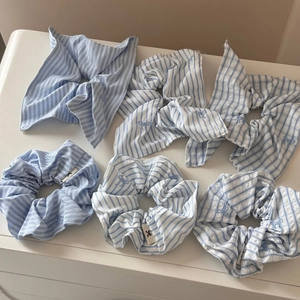 Close-up of six-piece blue striped hair scrunchies with delicate bow embroidery