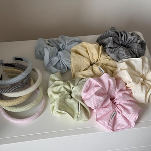 Close-up of colorful plaid hair scrunchies and headbands in sweet pastel tones
