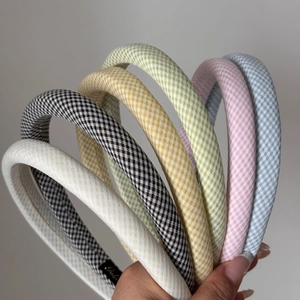 Detail of colorful plaid sponge headbands featuring a soft checkered fabric texture