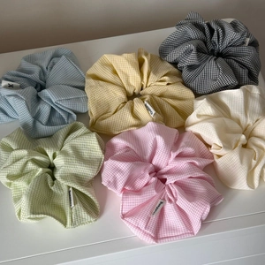 Detail of six oversized gingham and solid color scrunchies with soft cotton texture