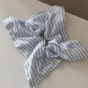 Detail of blue striped scrunchie featuring delicate embroidered butterfly bow patterns