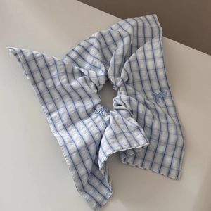 Detail of blue and white plaid fabric hair scrunchie with small embroidered butterfly bows