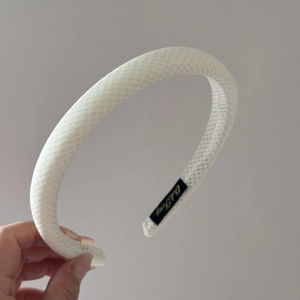 Detail showing white woven mesh texture and brand label on a padded headband