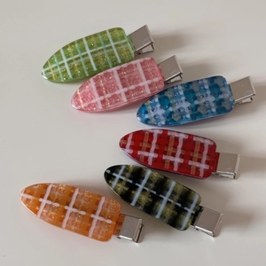 Lot de six barrettes à carreaux aux couleurs acidulées avec paillettes sur fond blanc