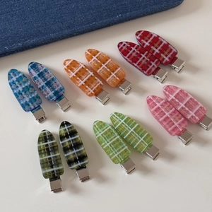 Vue détaillée de barrettes à cheveux à carreaux colorés avec finition en résine brillante