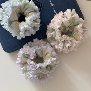 Lot de trois chouchous à fleurs avec volants dans les tons bleu, rose et violet