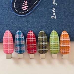 Gros plan de pinces à cheveux en acrylique à carreaux colorés avec paillettes