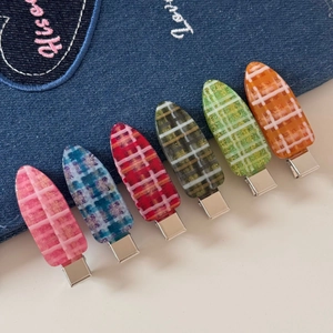 Gros plan de six barrettes en résine à carreaux colorés avec paillettes sur denim