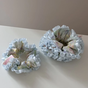 Vue détaillée d'un ensemble de chouchous floraux faits main avec bords en satin bleu