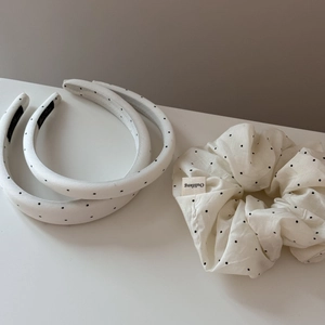 Detailed shot of white polka dot sponge headbands and a matching hair scrunchie set