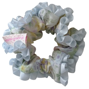 Chouchou floral avec motif de fleurs pastel et bordure à volants en satin bleu