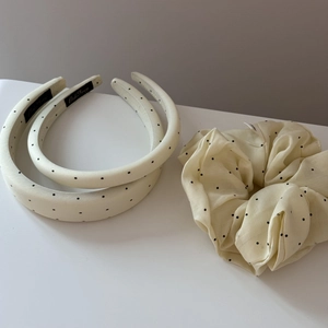 Close-up of cream polka dot headband set and scrunchie in smooth satin fabric