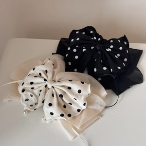 Détail des barrettes à nœuds en mousseline à pois avec petits pendentifs perles