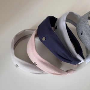 Détail de serre-têtes larges en tricot avec petits pendentifs en cœur de métal multicolores