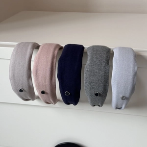 Gros plan de cinq serre-têtes en tricot aux couleurs pastel avec petits pendentifs cœur