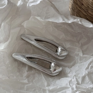 Lot de barrettes à cheveux en cuir argenté avec cœur métallique sur fond papier