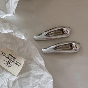 Détail de barrettes à cheveux argentées en forme de cœur avec une finition métal poli