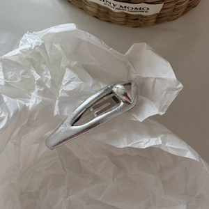 Barrette à cheveux argentée en forme de cœur sur papier blanc avec détails mats précis