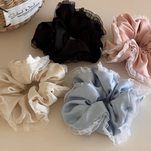 Detail of satin scrunchies in pastel colors with sheer organza ruffled edges