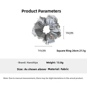 Close-up of gray fabric hair scrunchie with lace trim showing 14cm diameter size