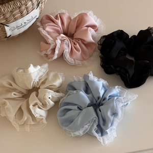 Detail of 4-pack satin scrunchies with white lace edges in pink, black, cream and blue