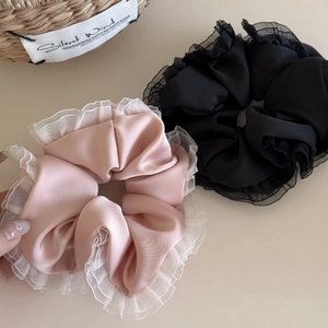 Pink and black satin ruffled scrunchies set with organza trim in a natural rustic setting