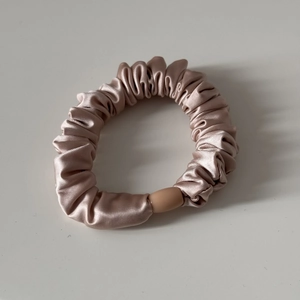 Detail eines Satin-Haargummis mit weichem Faltenstoff und stabiler Verbindungsschnalle