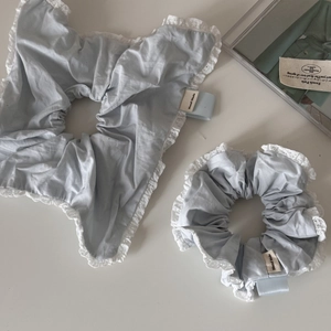Detailed macro view of light blue lace hair scrunchies with white embroidery edges
