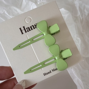 Lot de deux barrettes à cheveux en métal vert clair en forme de nœud sur carte blanche